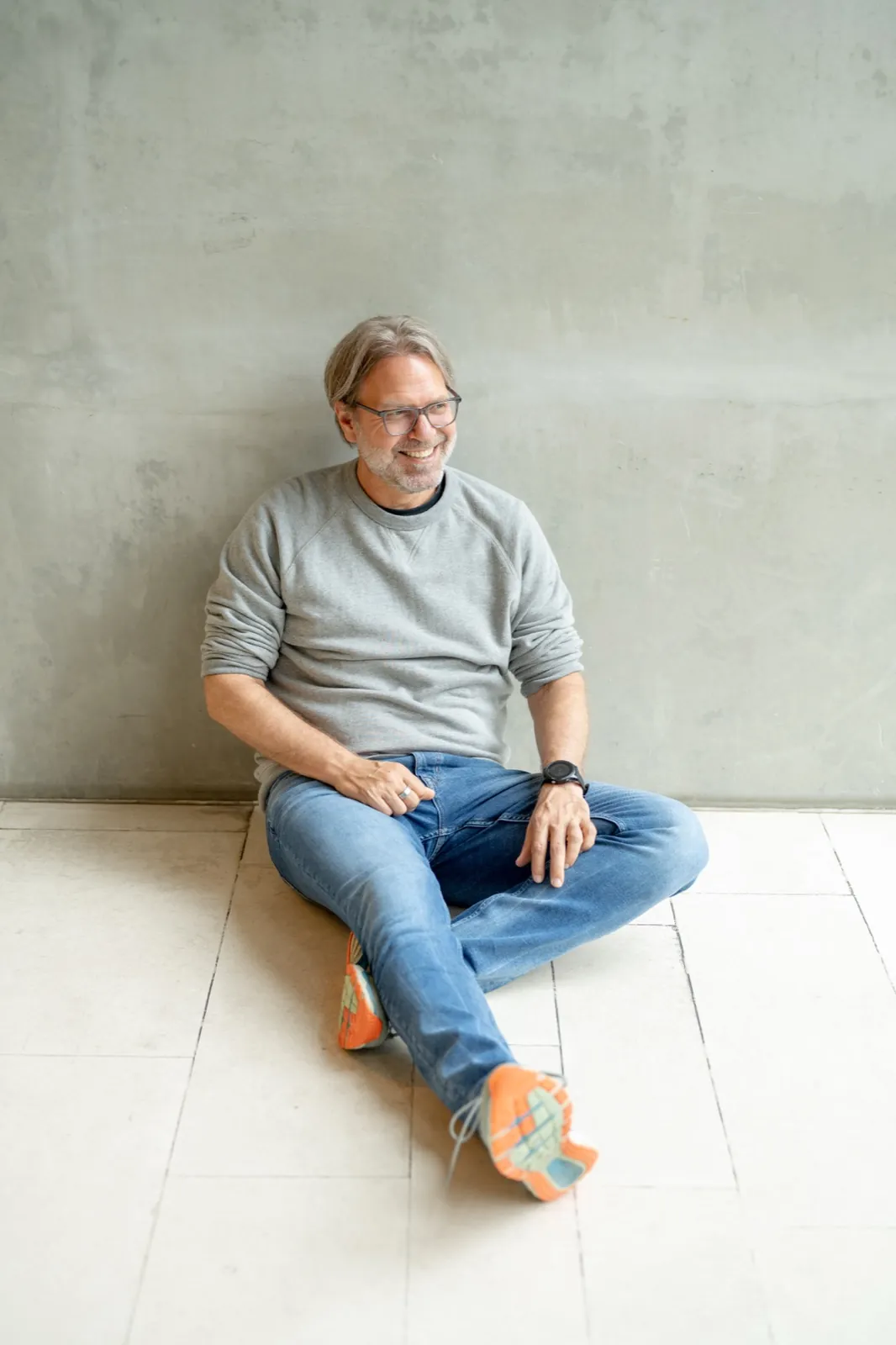 Ralf Lanwehr sitzt vor einer Betonwand